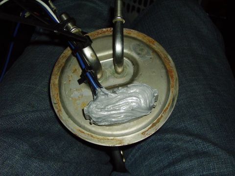 1991 Ford Bronco - A fuel pump assembly with wires and gray sealant is shown.