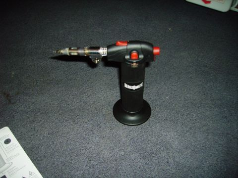 1991 Ford Bronco - A Bernzomatic torch is shown on a dark carpeted surface.