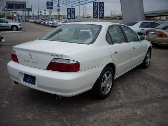 White Acura 3.2TL sedan, rear three-quarter view on a used car dealership lot