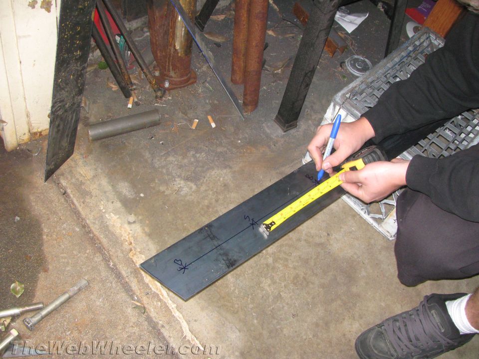 Metal bar with tape measure and marker, showing measurements and markings