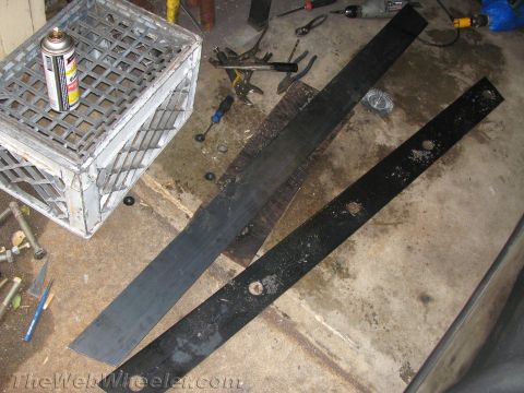 1987 Suzuki Samurai - Metal rock sliders and tools are laid out on a garage floor, ready for installation or modification.