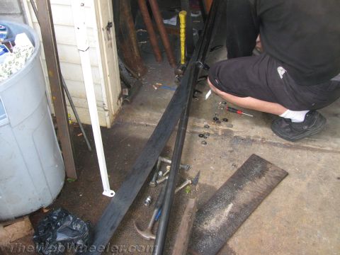 1987 Suzuki Samurai - Rock sliders and tools are laid out on a concrete floor, possibly for installation or repair.