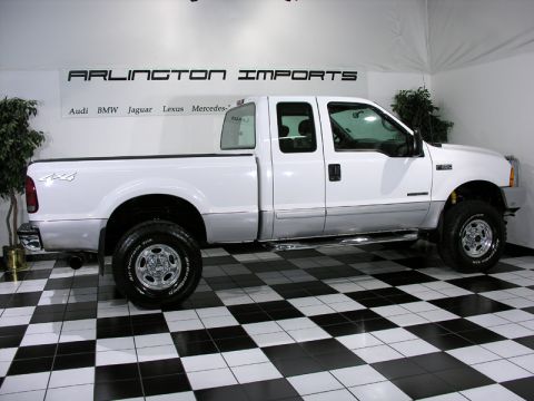 2001 Ford F-250 - This white 2001 Ford F-250 pickup truck is shown from the side in a showroom.