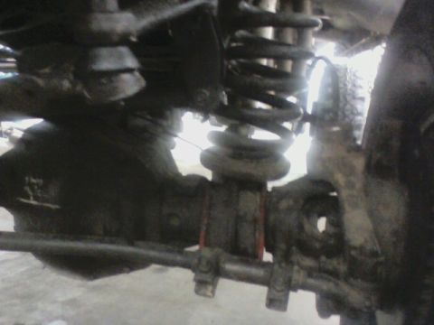 1992 Ford F-350 - This image shows the underside of a vehicle, focusing on the suspension system and front axle components.