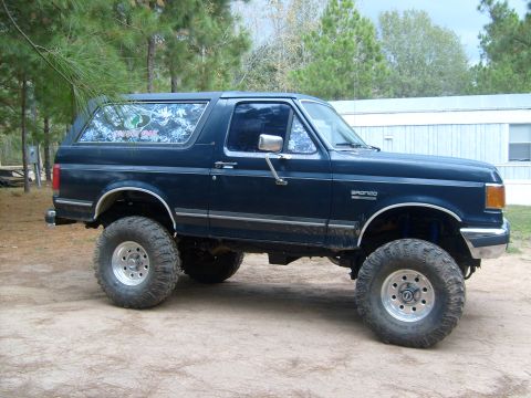 1989 Ford Bronco - Lifted 1989 Ford Bronco with custom window decal and large off-road tires.