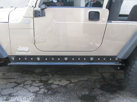 1987 Suzuki Samurai - This Jeep Scrambler features prominent rock sliders along its side, with the "Jeep Scrambler" badge clearly visible.