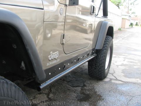 1987 Suzuki Samurai - A Jeep Scrambler is shown with custom side armor and aggressive tires.