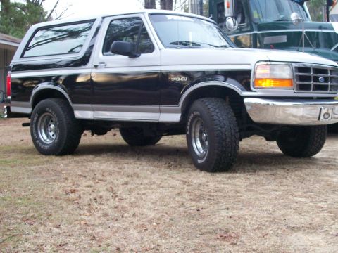 1996 Ford Bronco - A 1996 Ford Bronco with a black and silver two-tone paint job is shown from the front three-quarter view.