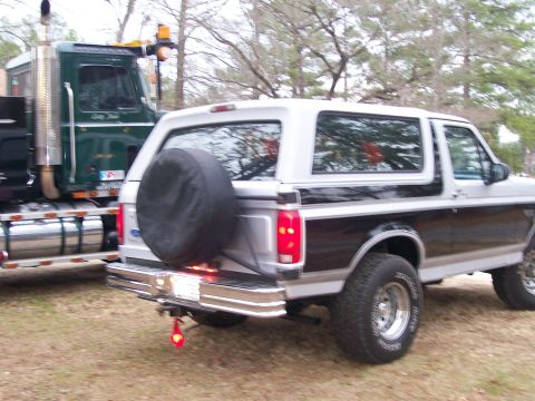 1996 Ford Bronco - This 1996 Ford Bronco is seen parked next to a large green semi-truck.