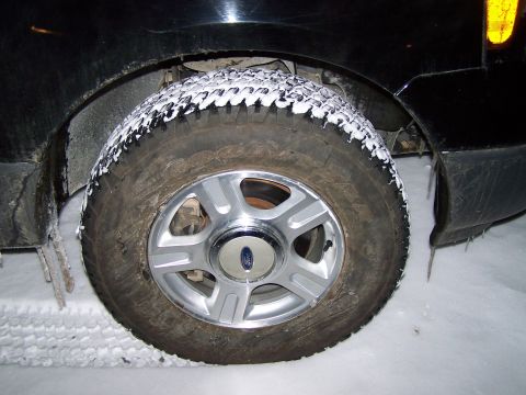 2004 Ford Expedition - Front wheel of a 2004 Ford Expedition covered in snow during winter weather.