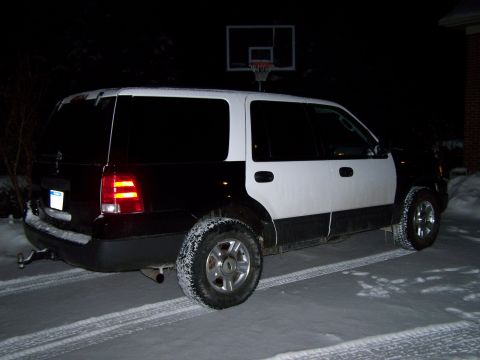 2004 Ford Expedition - This two-tone SUV is parked outside in the snow at night, with a basketball hoop visible.