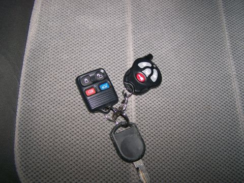 2004 Ford Expedition - A set of car keys and fobs are shown on a textured seat cover.