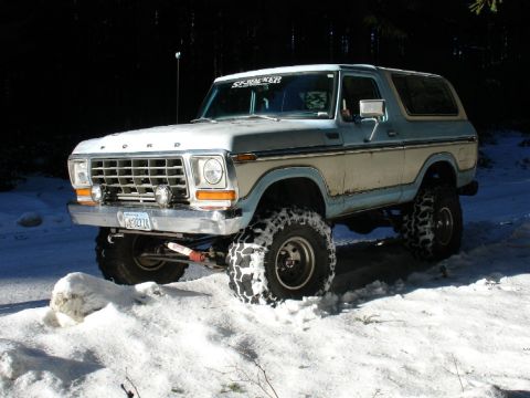 1978 Ford Bronco - A lifted 1978 Ford Bronco navigates a snowy terrain, its off-road capabilities.