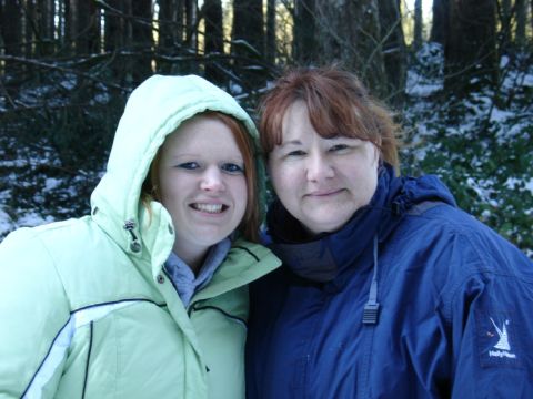 1978 Ford Bronco - Two women pose for a photo in a snowy forest, wearing warm winter jackets.