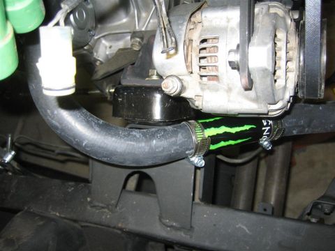 1987 Suzuki Samurai - A close-up view of an engine component a custom hose with a Monster Energy logo and a Supermotors.net watermark.