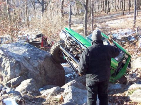 1978 Ford Bronco - Two off-road vehicles navigate a rocky terrain with snow patches.