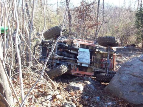 1978 Ford Bronco - This off-road vehicle has rolled onto its side amidst trees and rocks.