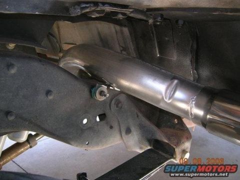 1986 Ford Bronco - Close-up view of the exhaust system and suspension components of an unidentified vehicle.