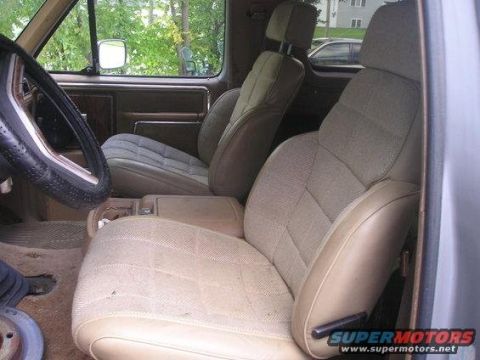 1986 Ford Bronco - The interior features tan cloth seats with a patterned design and a brown dashboard.