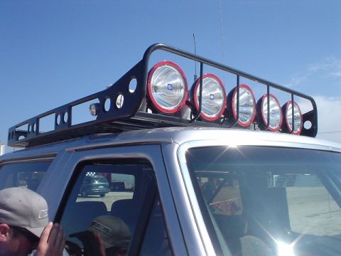 1986 Ford Bronco - This SUV is equipped with a substantial roof rack several large, round auxiliary lights.