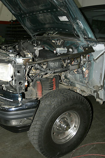 1986 Ford Bronco - Front view of a 1986 Ford Bronco with the hood open, revealing the engine and suspension components.