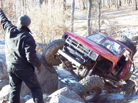 1978 Ford Bronco - A red Toyota pickup truck navigates a rocky obstacle course.