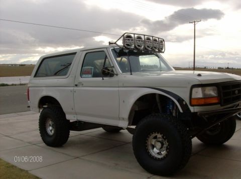 1986 Ford Bronco - This modified Ford Bronco features large off-road tires and a light bar on the roof.