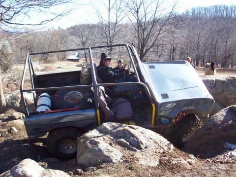 1978 Ford Bronco - This heavily modified off-road vehicle, equipped with a roll cage and spare tire, tackles challenging rocky terrain.