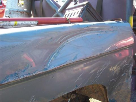 1978 Ford Bronco - The body panel shows significant damage, including dents and numerous scratches.