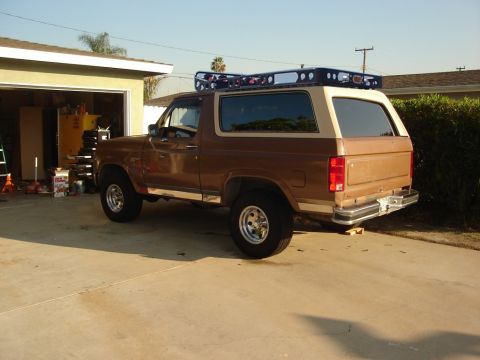 1986 Ford Bronco - This Ford Bronco is parked in front of a garage with a roof rack installed.