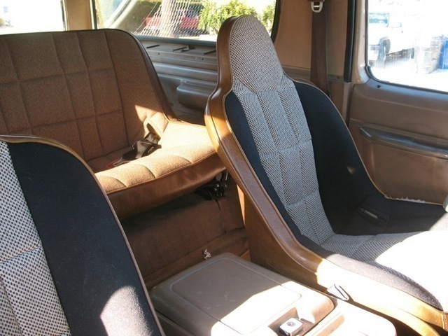 Interior of a 1986 Ford Bronco showing front bucket seats and rear bench seat