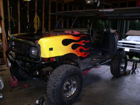 1979 Ford Bronco - This heavily modified vehicle is in a garage, with another truck visible in the background.