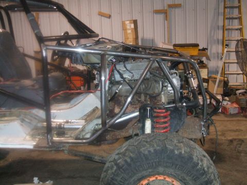 1995 Ford Bronco - This vehicle is undergoing modifications, a prominent roll cage and exposed engine components.