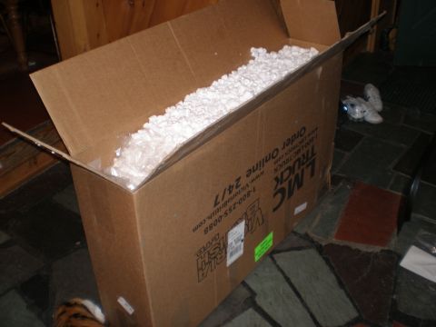 1995 Ford F-150 - A large cardboard box, filled with packing peanuts, sits open on a stone floor.