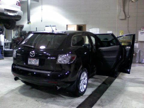 2007 Mazda CX-7 - A black 2007 Mazda CX-7 is shown from the rear in a garage with another vehicle overhead.