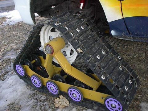 1987 Suzuki Samurai - A vehicle is fitted with a snow track system, replacing its wheels for off-road traction.