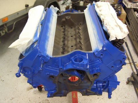1996 Ford Bronco - A blue painted engine block is prepared for further work, with masking tape and paper protecting sensitive areas.