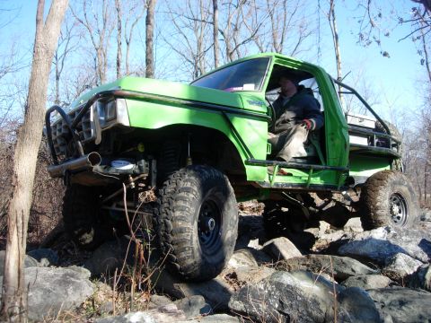 1978 Ford Bronco - A modified 1978 Ford Bronco navigates a rocky trail with a driver inside.