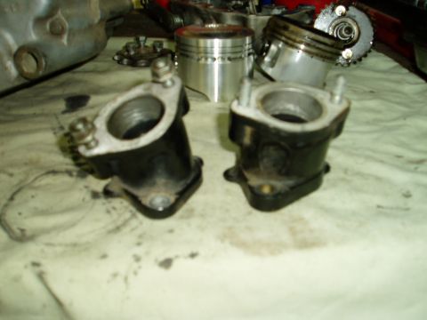 2000 Ford E350 - Engine parts, including intake manifolds and pistons, are laid out on a surface.