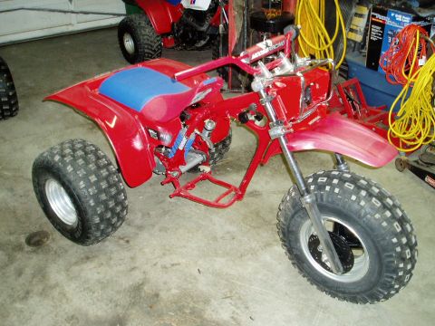 2000 Ford E350 - A red three-wheeled ATV is in a garage, with another ATV visible in the background.