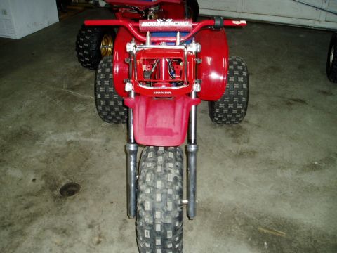 2000 Ford E350 - A red Honda three-wheeler is parked indoors, with another similar vehicle visible behind it.