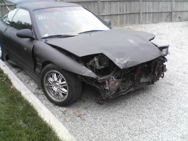 Black 1995 Ford Probe with significant front-end damage