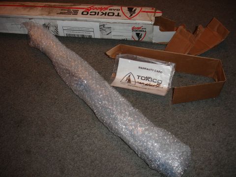 1993 Ford Taurus - Tokico gas shocks box and a shock absorber are on a carpeted surface with a warranty card.