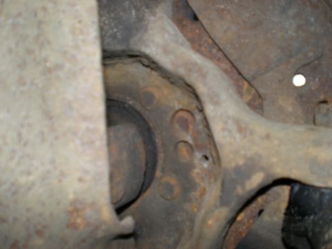1995 Ford F-150 - A close-up view of a heavily rusted suspension component, with the Supermotors.net watermark visible in the lower right corner.