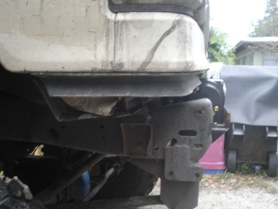 Vehicle frame with winch mount, showing rust and damage