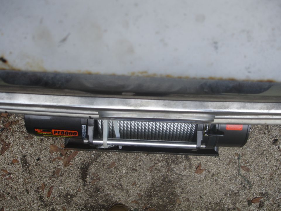 Winch with PE8000 label mounted under a vehicle's bumper