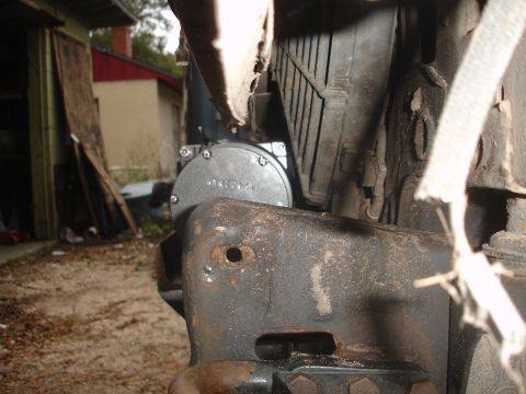 1989 Ford Bronco - Detail of a winch mount assembly, showing a circular component with embossed lettering and part of the vehicle's frame.