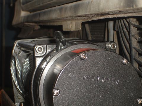 1989 Ford Bronco - A winch is mounted to the front of a vehicle, with visible text indicating its serial number.
