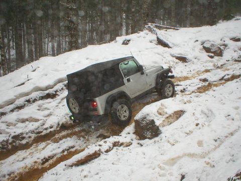 2005 Jeep Wrangler - A Jeep Wrangler navigates a challenging snowy and muddy terrain during winter conditions.