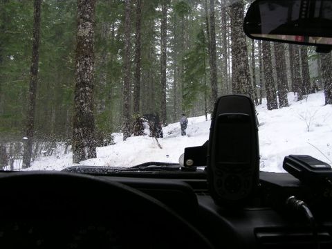 2005 Jeep Wrangler - Driving through a snow-covered forest with trees on either side of the road.
